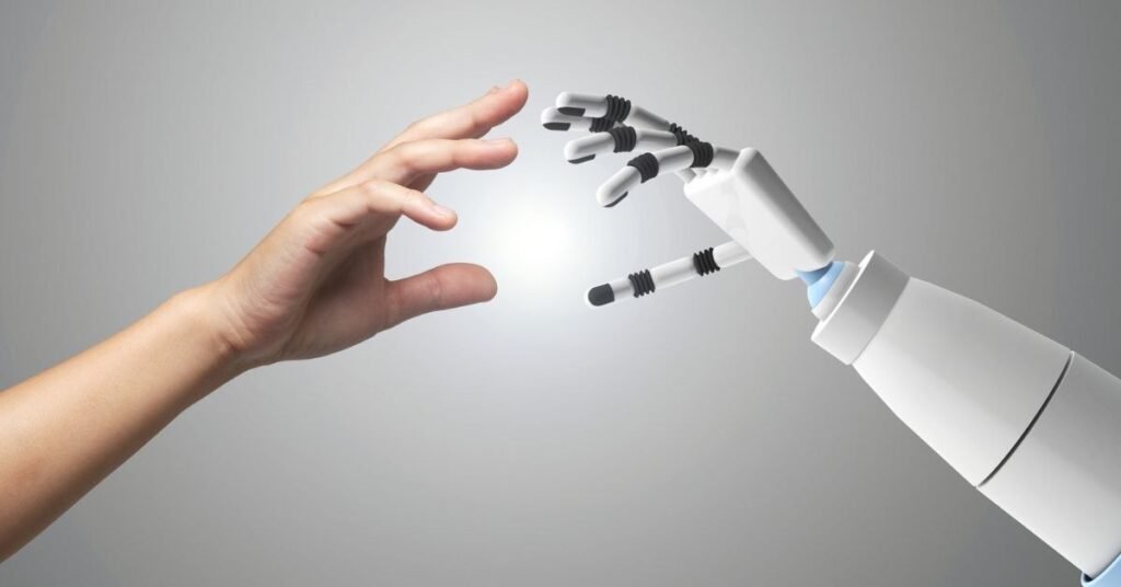 Robot hand reaching toward a human hand, symbolizing human–AI interaction and future technology.