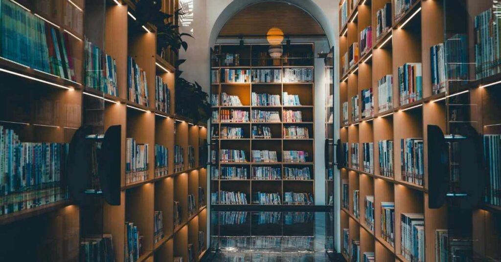Modern library interior with tall bookshelves, warm lighting, and reading area in a quiet study space. peaceful